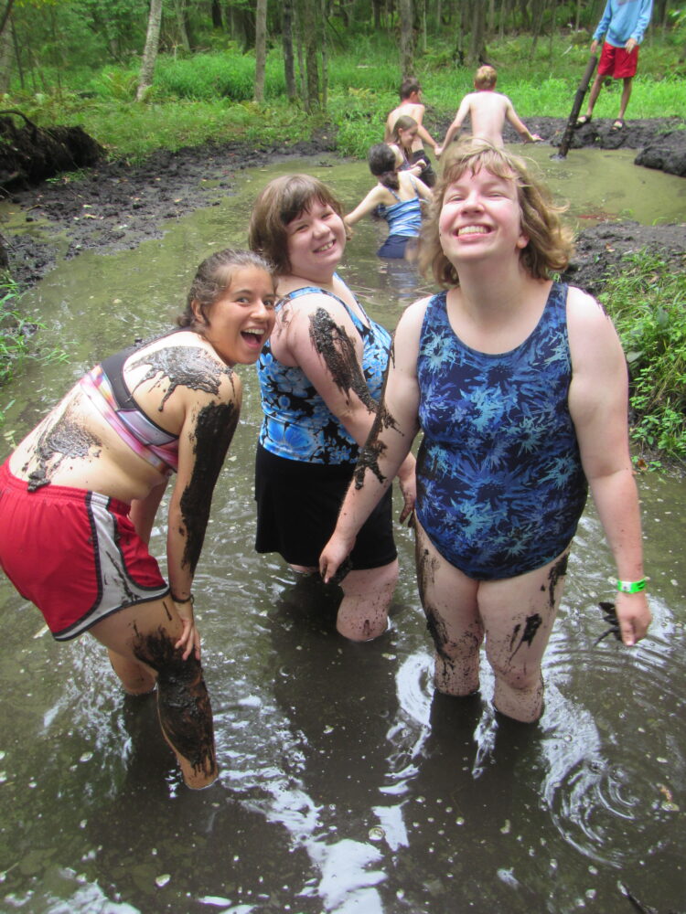 Photo of group standing in the mud pit and smiling