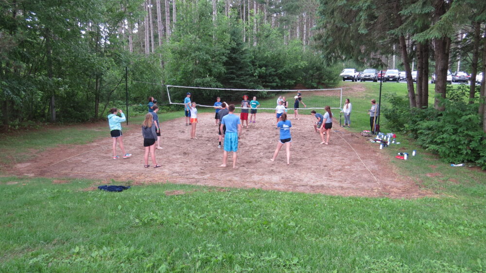 Photo of group playing sand volleyball