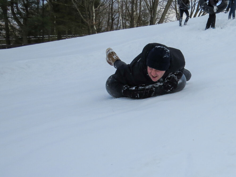 Photo of a person sledding in a tube down a hill