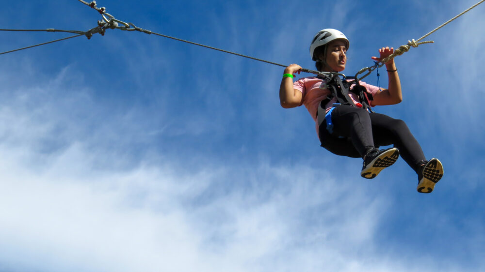 Photo of a person in the air on the giant swing about to pull their release to swing in the air