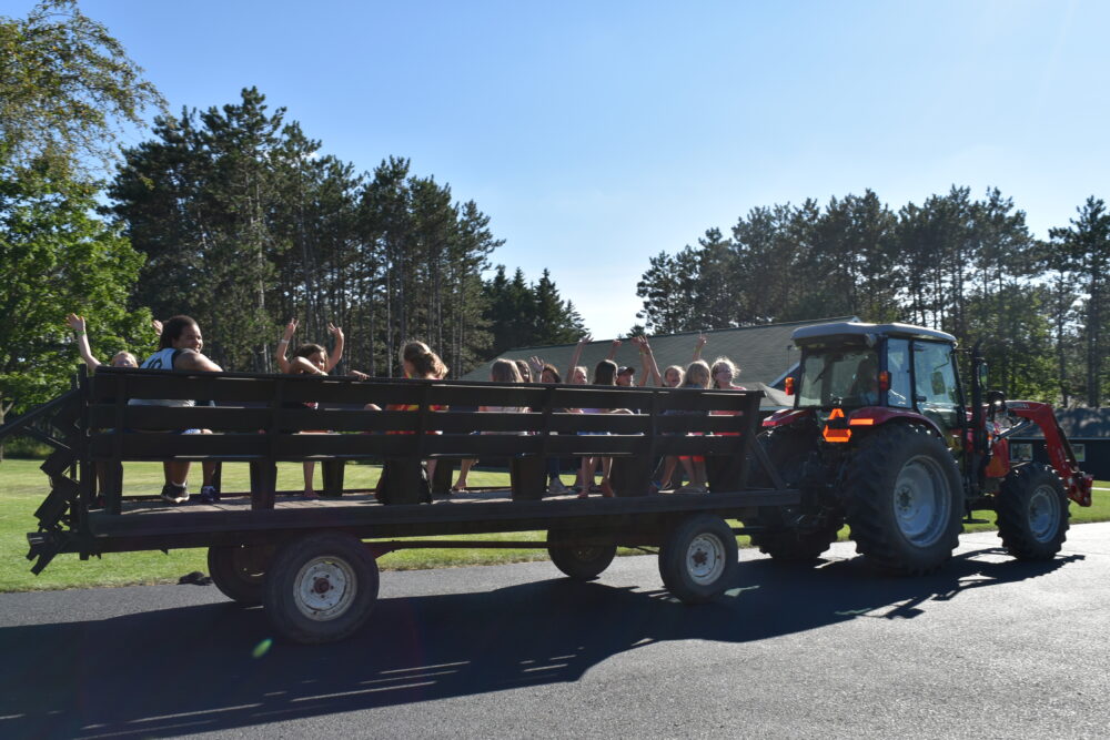 Photo of people waving from the wagon being pulled by a tractor