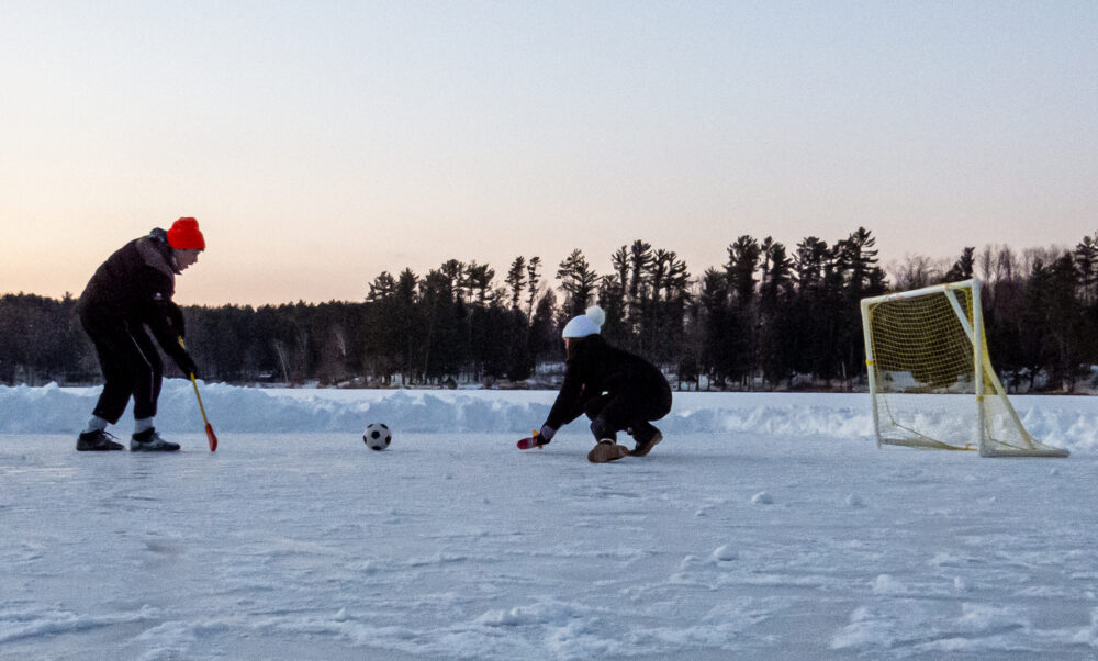 Photo of people playing broom ball on the lake